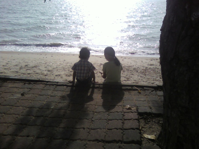 cousins sitting overlooking at the beach
